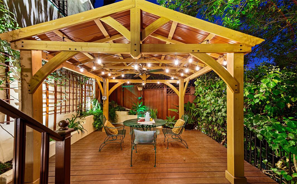 A backyard featuring a stunning tin-roofed pavilion for al fresco dining