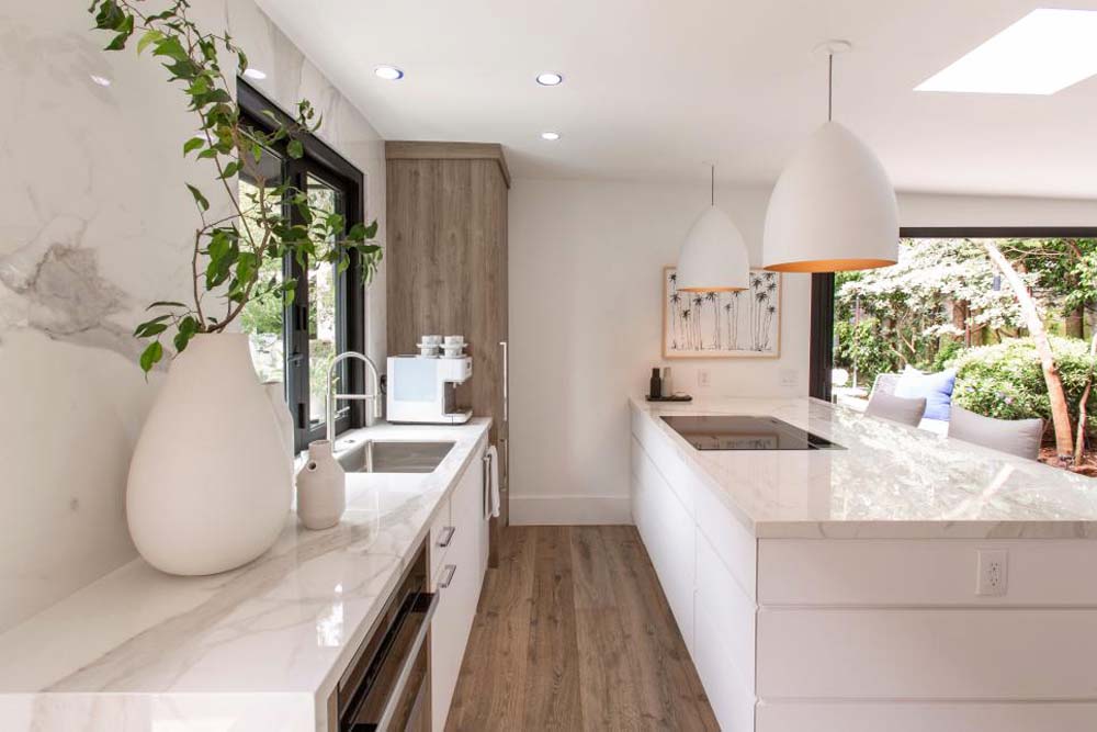 The renovated kitchen with a marble-topped island and plenty of storage space