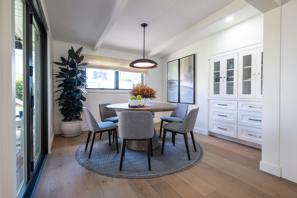 A renovated dining room with a space-saving circular table and built-in hutch
