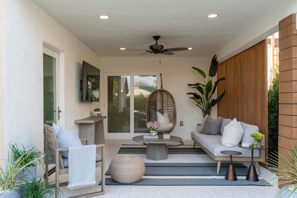 Neutral furniture pieces on the renovated back patio gives the space an airy living room feel