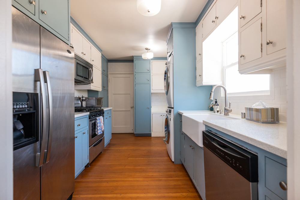 The narrow kitchen before the renovation with pastel blue walls and limited storage space