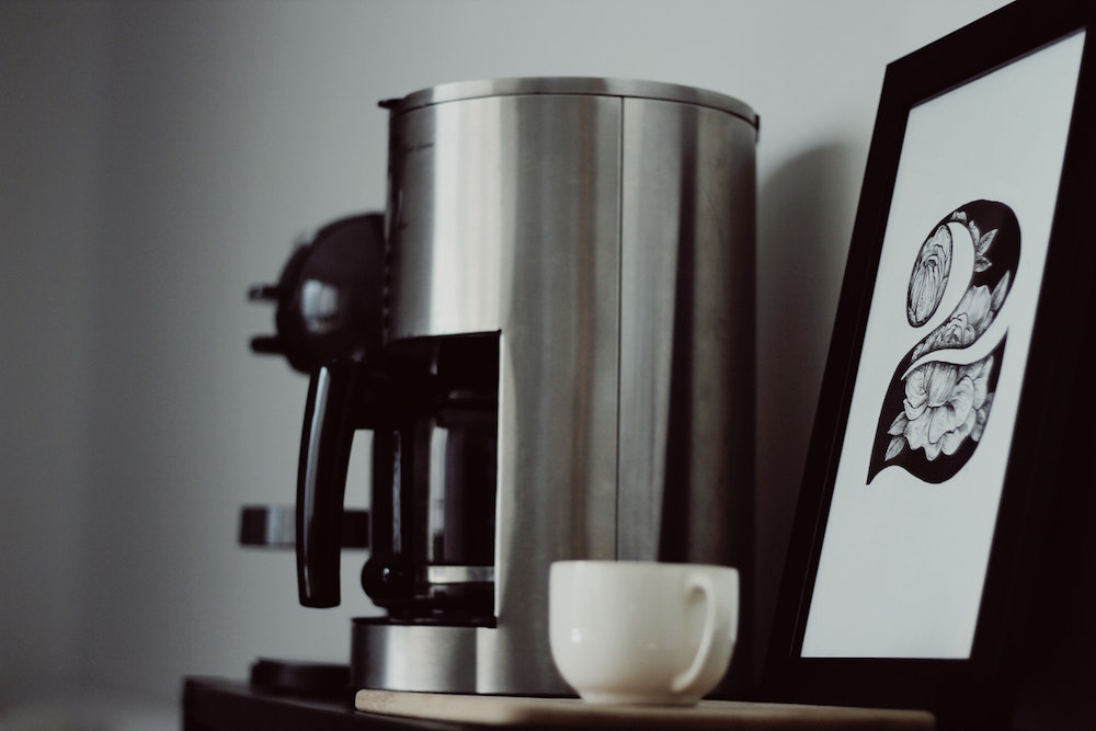 coffee-making station with stainless-steel coffee pot an framed art