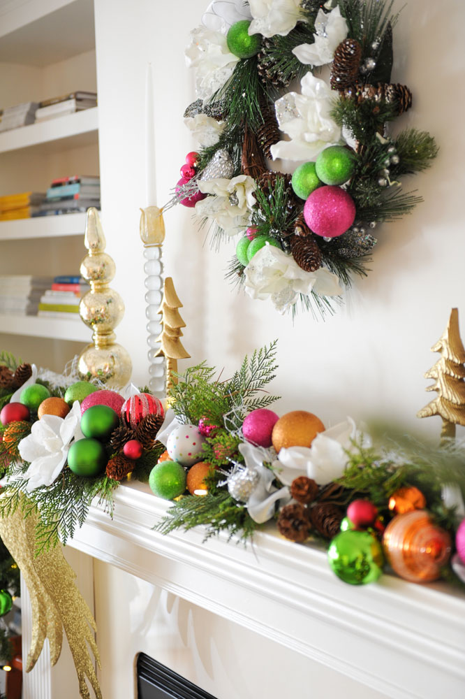 close up of wreath over mantel with green, orange and pink balls and standing gold ornaments