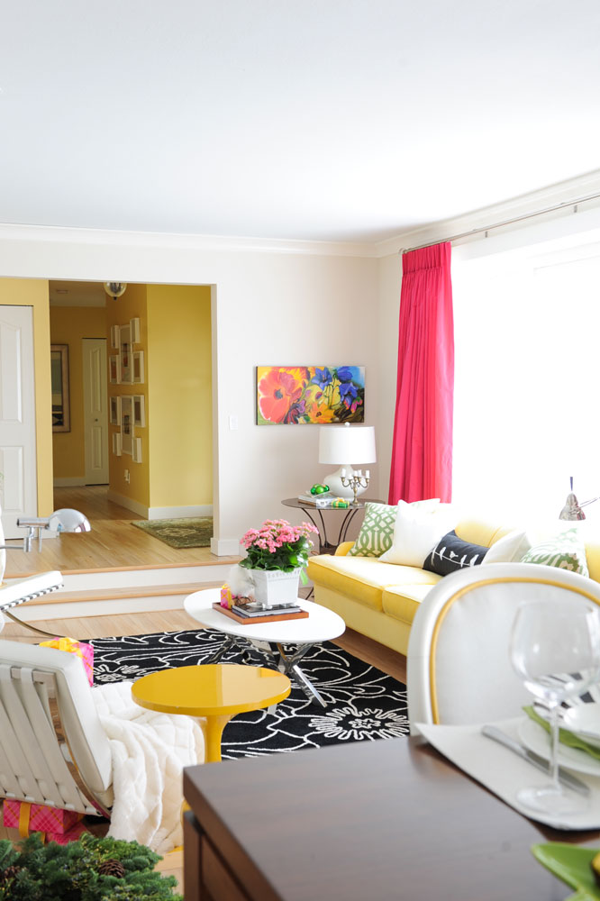 white wall living room with fuchsia curtains, yellow sofa and two steps up to yellow wall hall