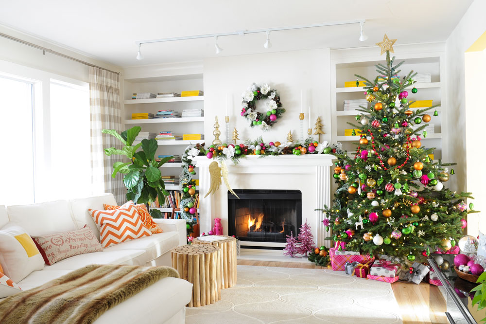 white fireplace flanked by bookshelves with yellow and white mags and colourful xmas tree to right
