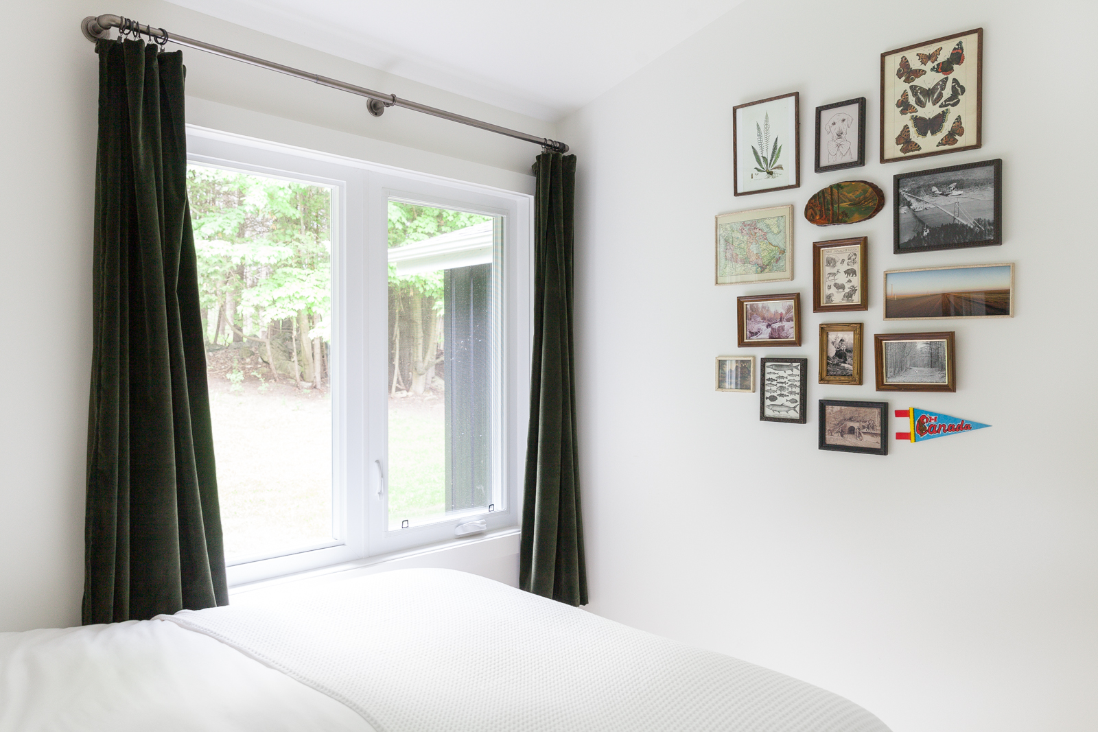 A small gallery wall in a bedroom featuring both family photos and vintage images