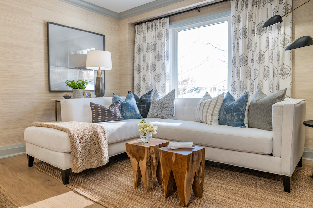 comfy living room with plush beige sectional topped with knit blanket and array of throw pillows