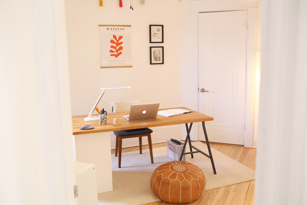 minimal home office with wood desk and beige area rug