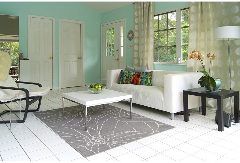 A white front room accented with aqua walls and patterned curtains