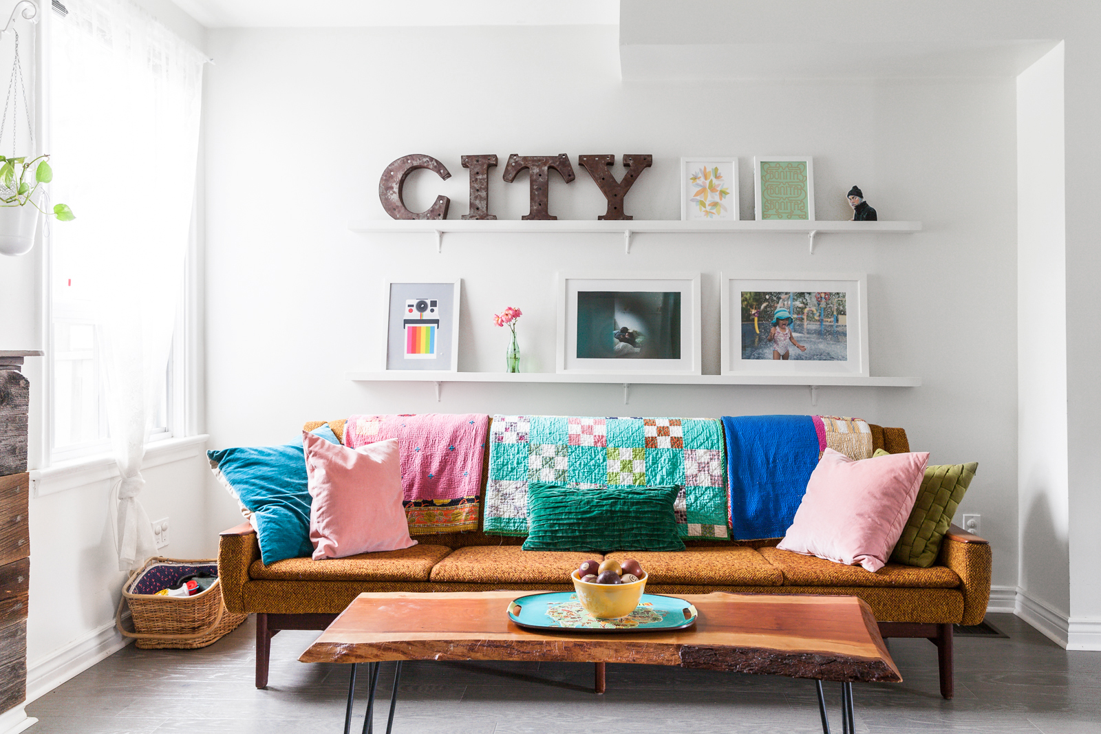 white living room with vintage sofa and floating shelves with CITY letters