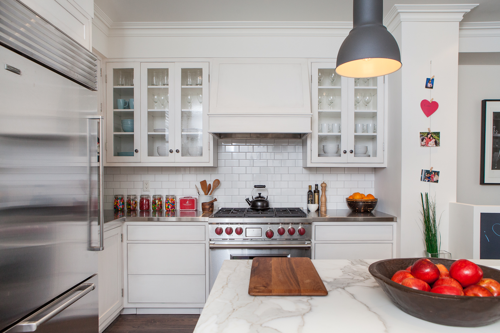 Timeless white kitchen with glass-fronted cabinetry doors to display dishware.