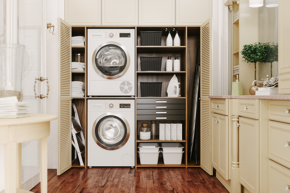 A well-organized laundry room with stacked washer-dryer and plenty of storage space and shelving
