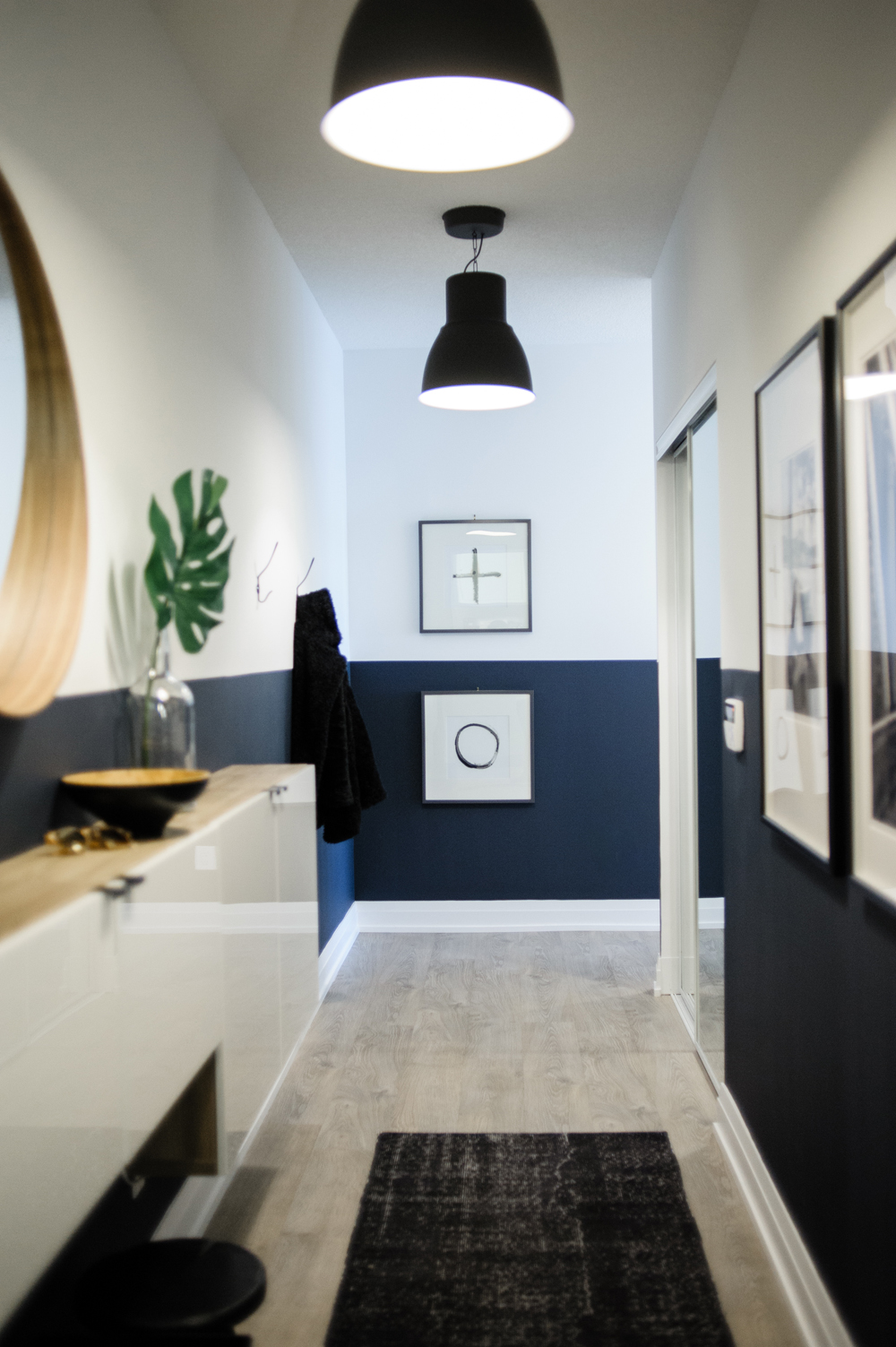 A long front entrance with half the wall painted in a deep navy blue and the rest in white