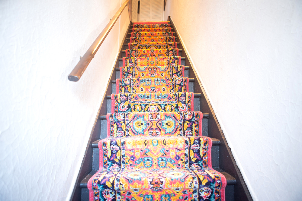 A brightly patterned carpet runner leading up a staircase