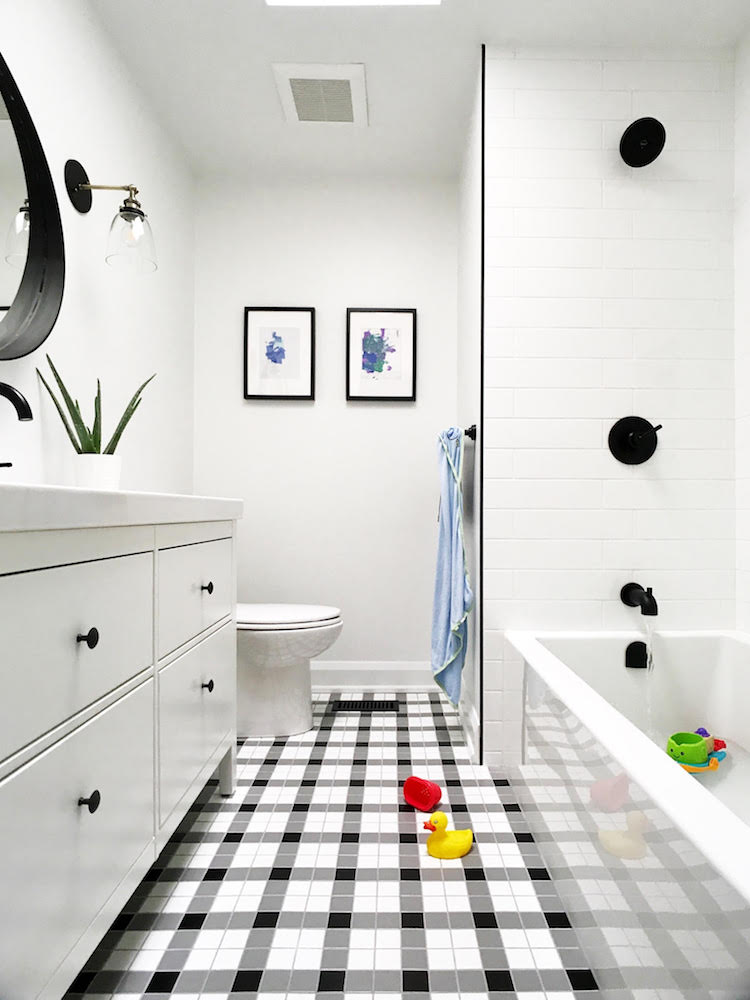 white bathroom with plaid tiled floor and framed art on walls