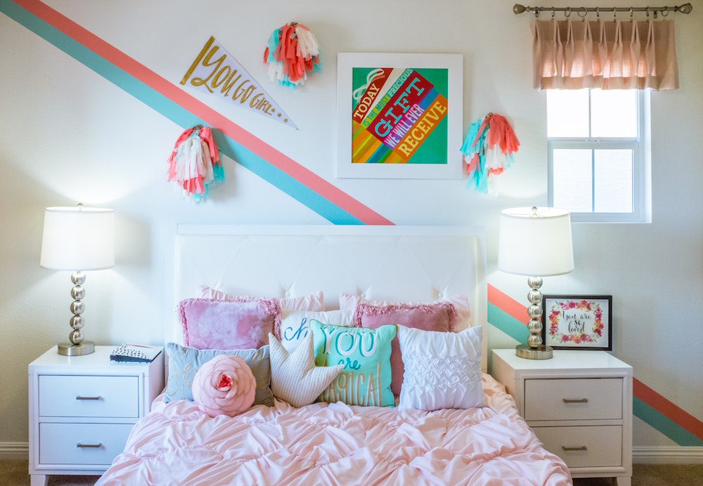 girls bedroom with accent wall and bed with colourful pillows
