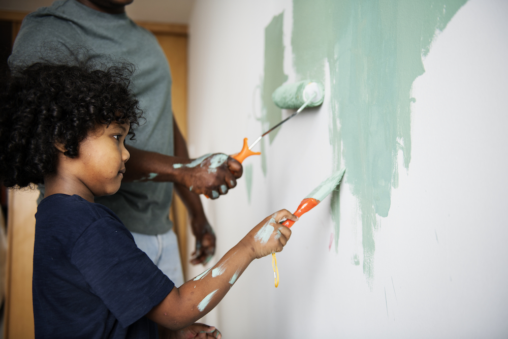 father and son painting white wall teal