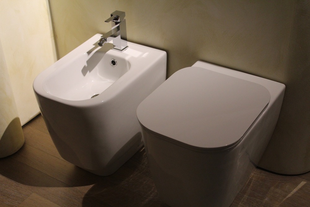 white bidet and toilet in beige room