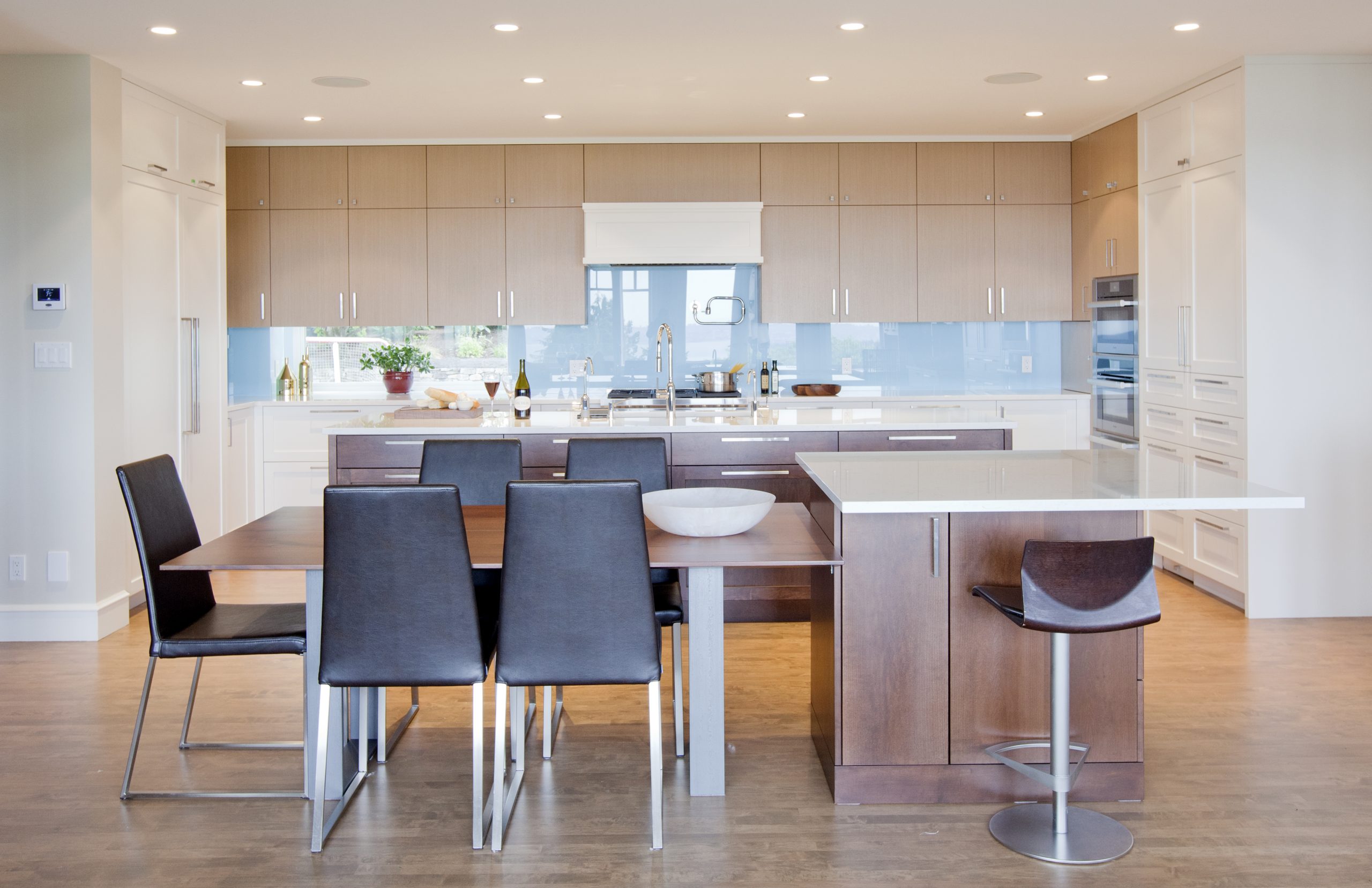 Modern neutral kitchen with watery blue glass backsplash.