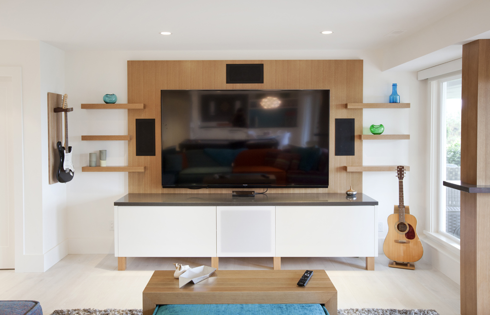 A large television flanked by floating shelves.