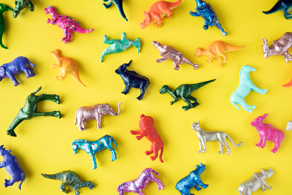 A collection of small toys, such as dinosaurs, horses and lions