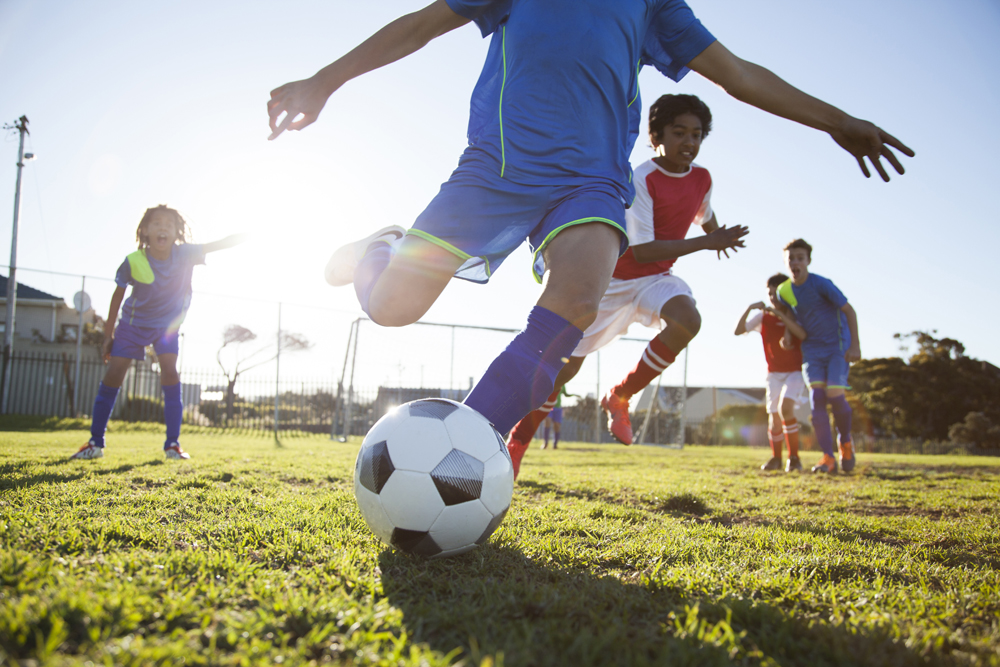 Legs kicking a soccer ball during a game