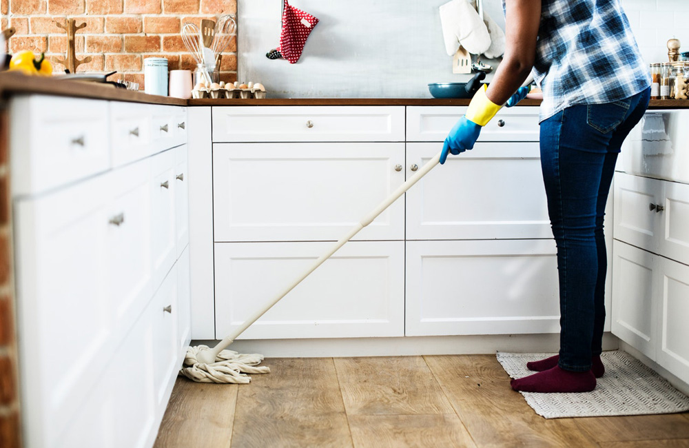 A woman mopping the floor in her kitchen