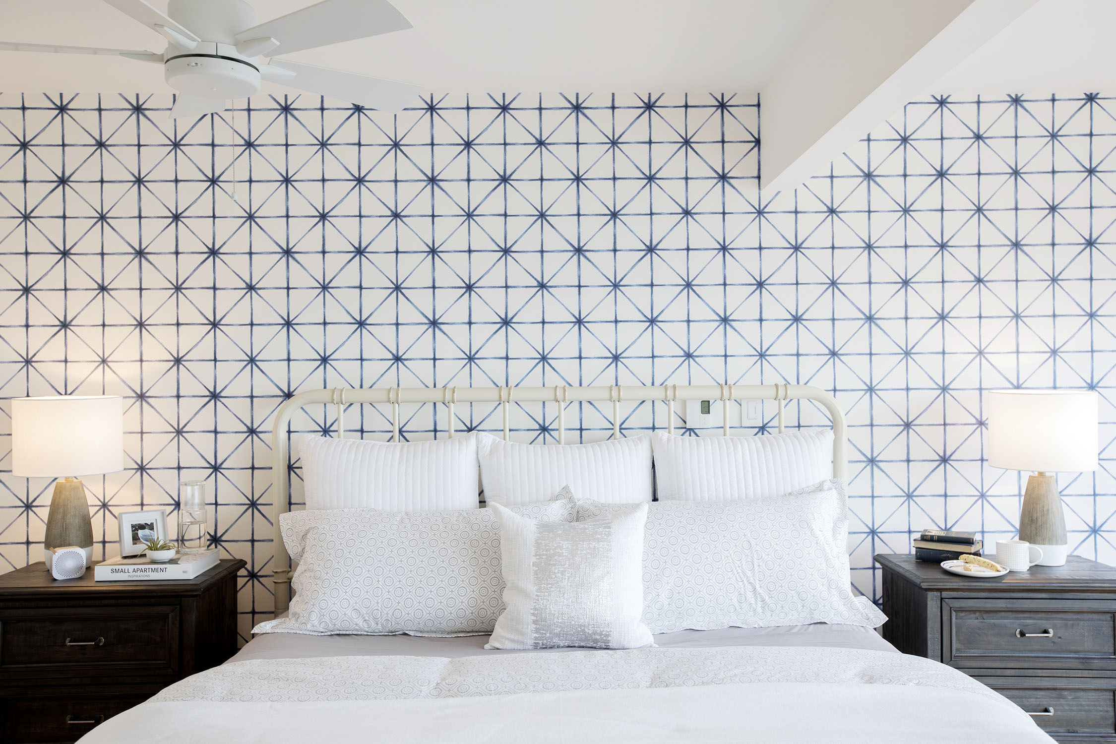 Bedroom with navy blue ikat-printed wallpaper.