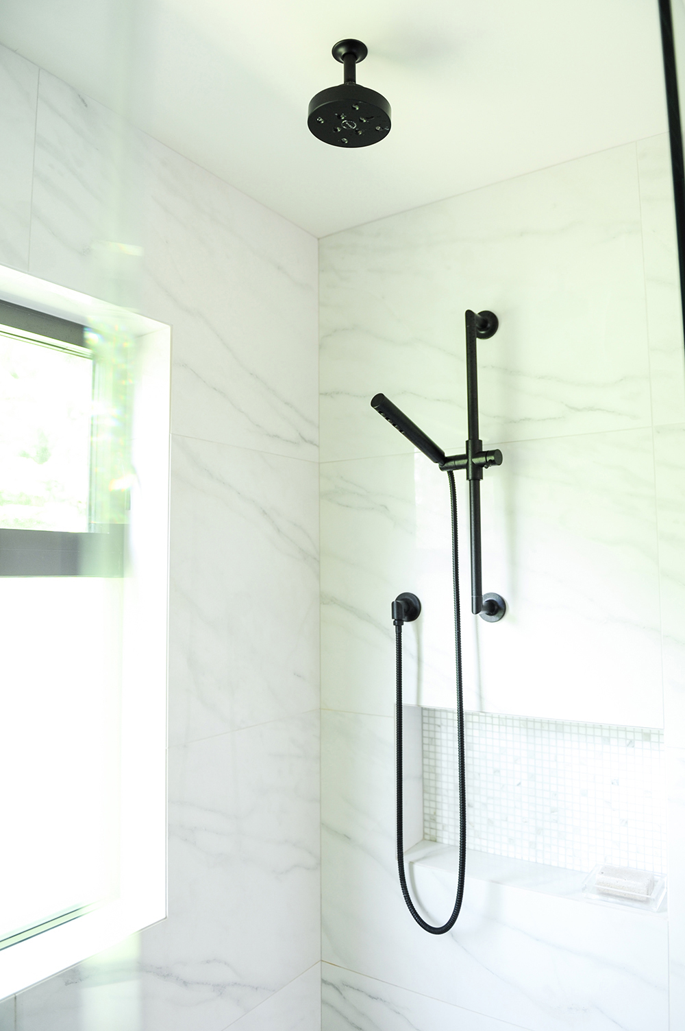 Black matte exposed pipes in white marble standing shower
