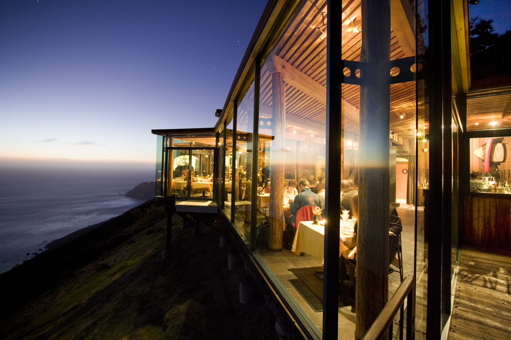 Restaurant with glass walls overlooking the Pacific Ocean in the evening