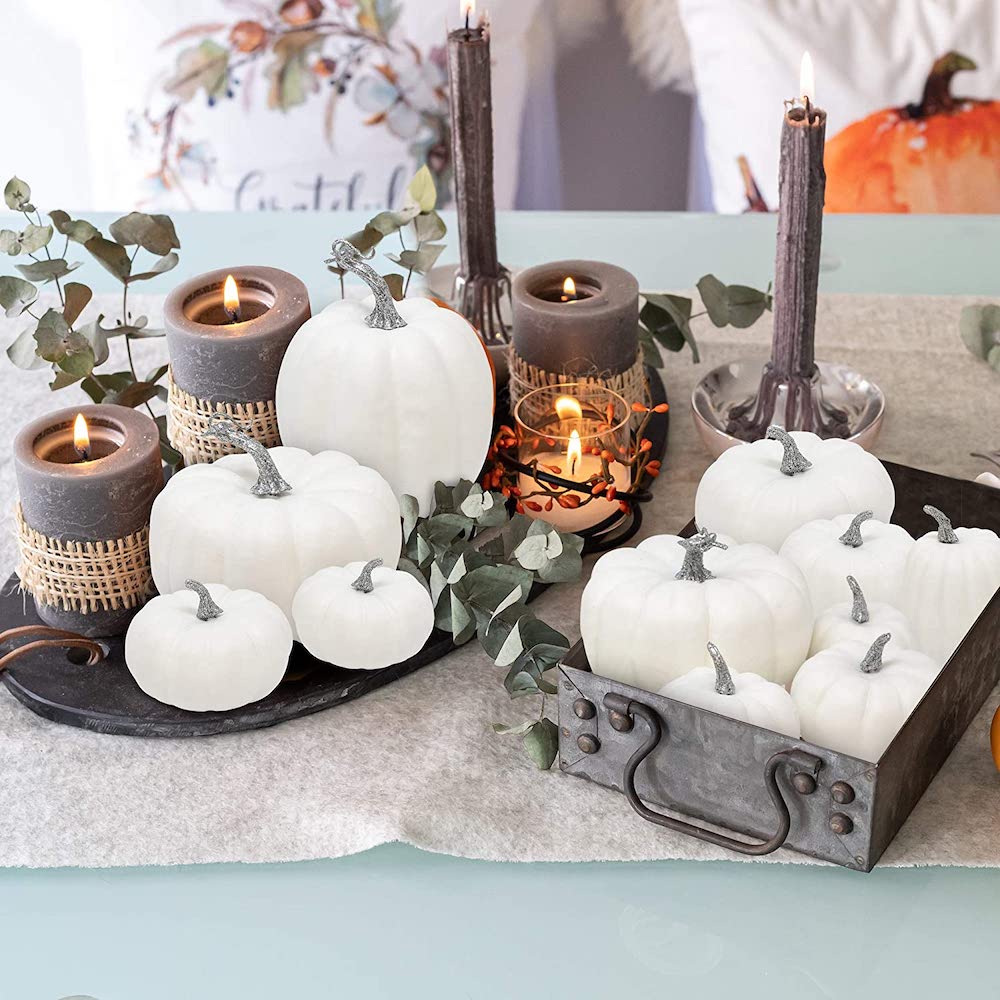 table top with white mini pumpkins and candles