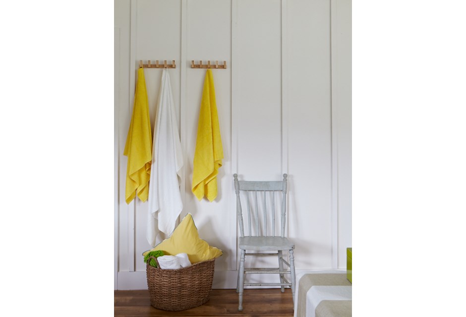 A white mudroom with hooks for brightly coloured towels