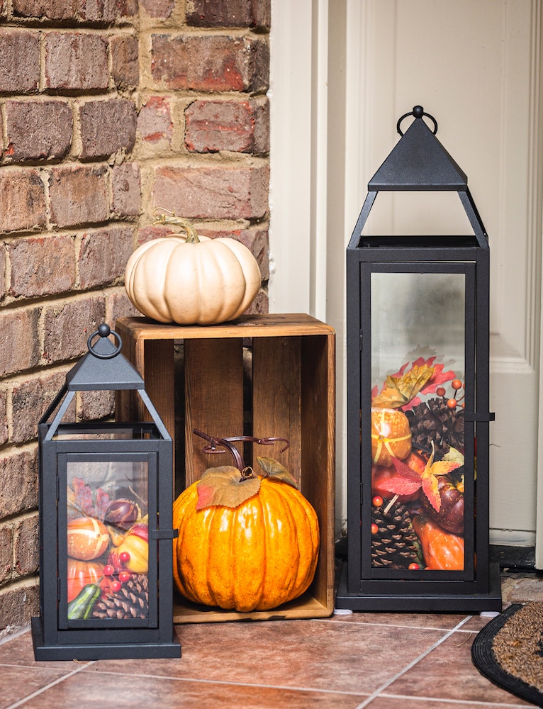 lanterns filled with fall items on front porch