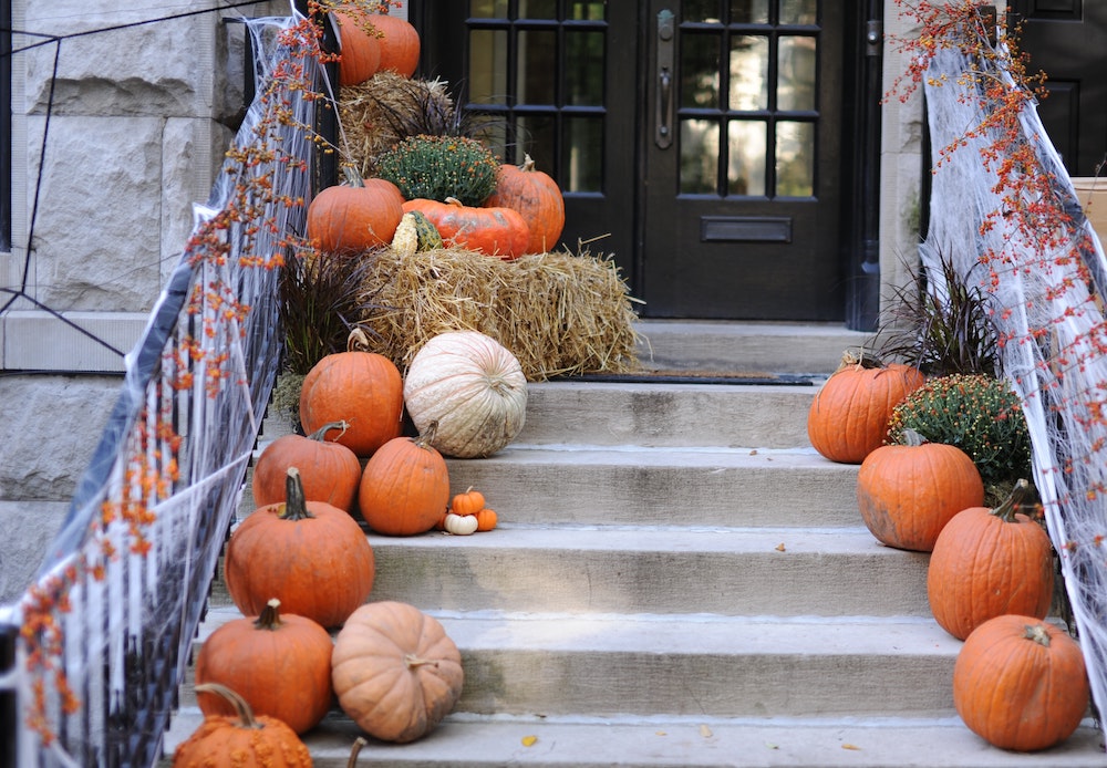 stairs and front porch with pumpkins and hay