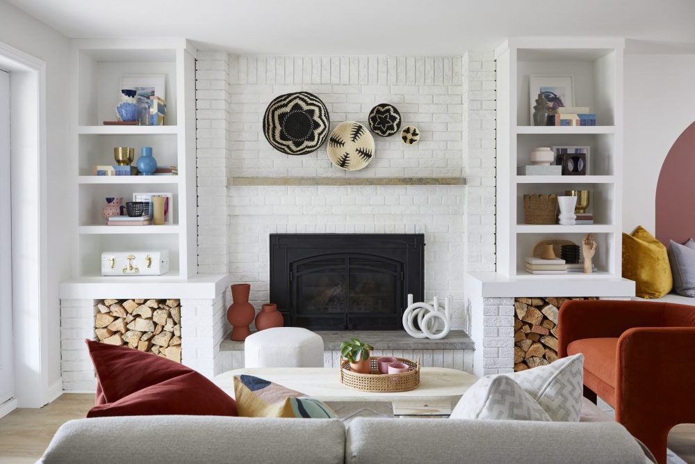white living room with round wall art above mantel
