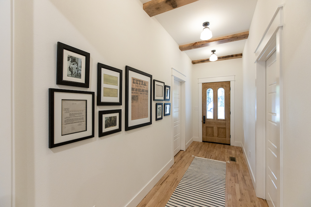 white hallway with black-framed photos and documents