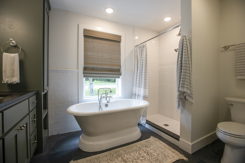 bathroom with white freestanding tub in front of window