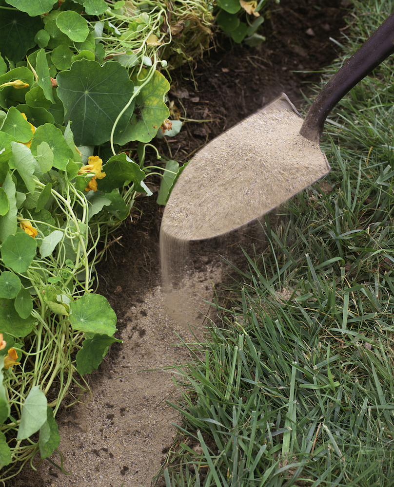 shovel pouring out sand garden edging