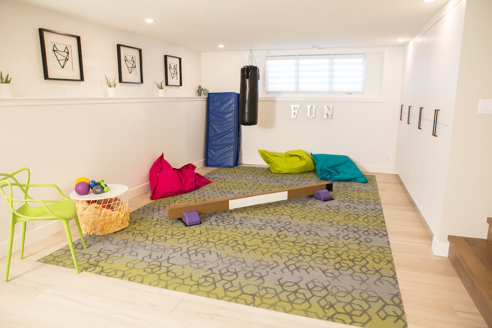 A small basement playroom/family gym combo with exercise equipment for all ages