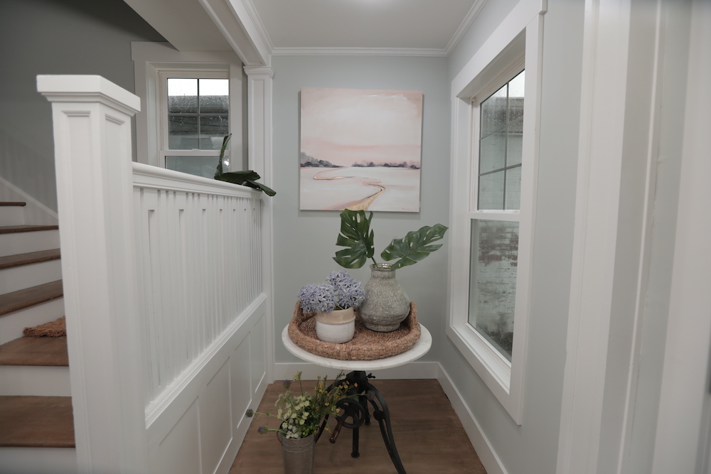 front entryway with light walls, white trim and table with basket