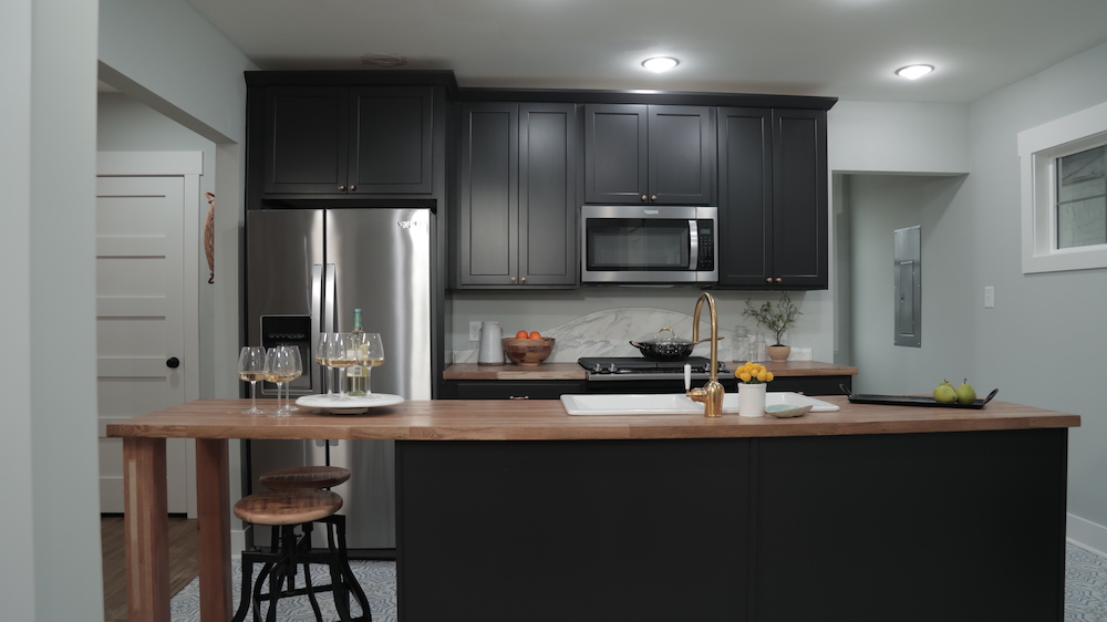 kitchen with dark grey cabinets and centre island with butcher block countertop