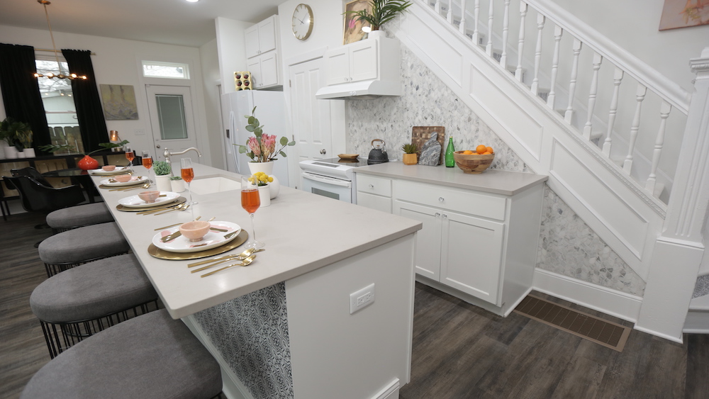 white open-concept kitchen with large centre island and tiled backsplash