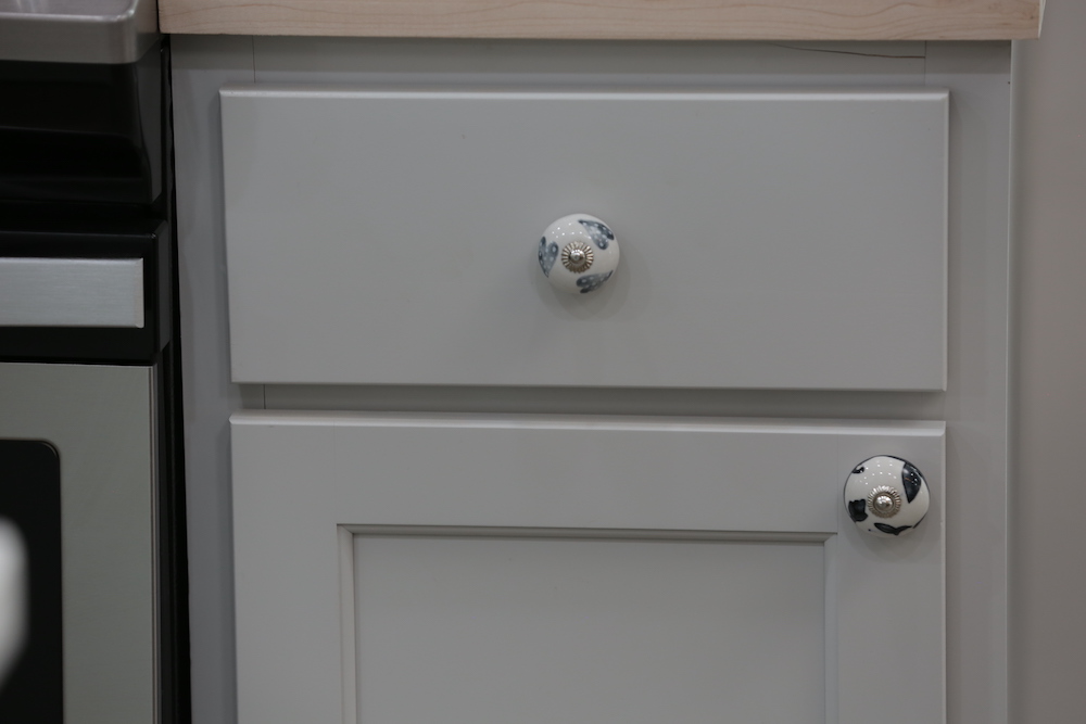 close up of kitchen cabinets with mixed painted hardware knobs