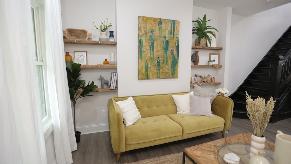 white living room with wood shelving and yellow couch