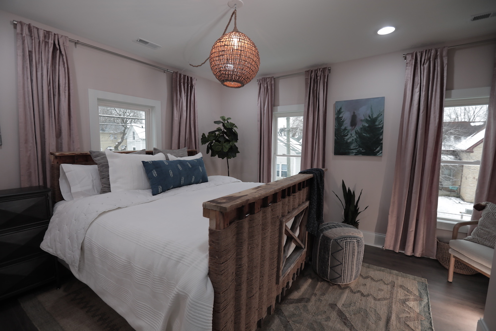 pink master bedroom with hanging light and pink curtains