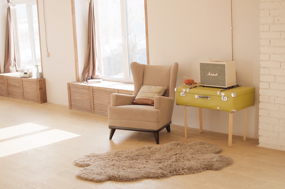 neutral living room with chair and lime-green suitcase table