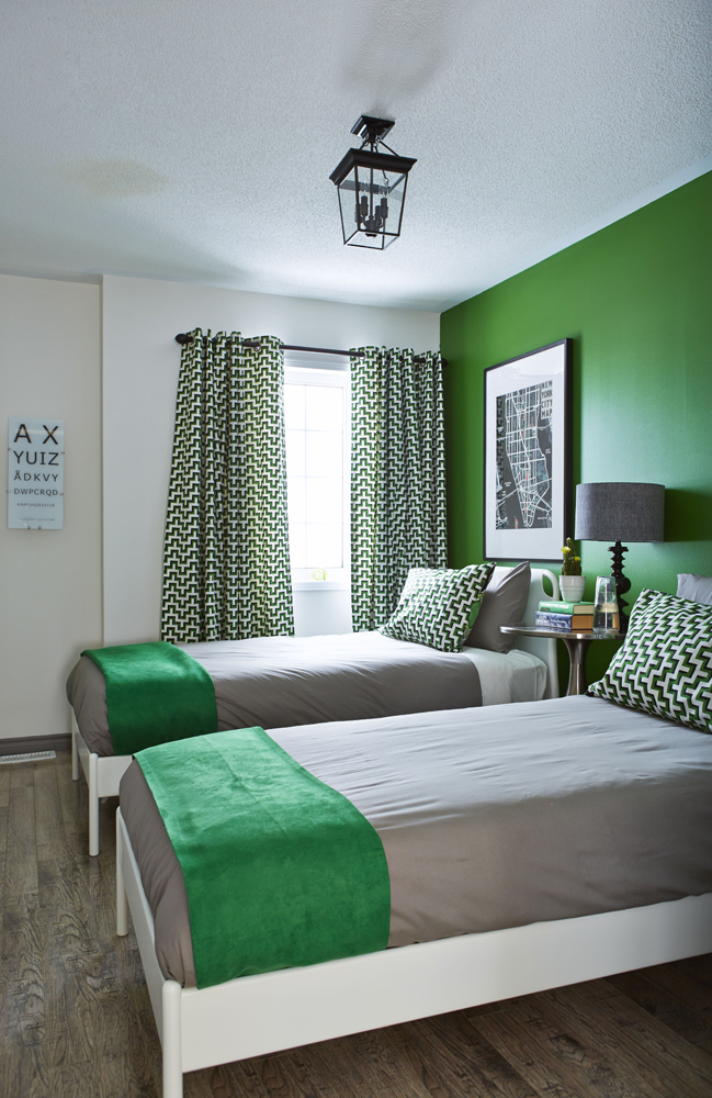 one green wall in bedroom with grey and green twin beds