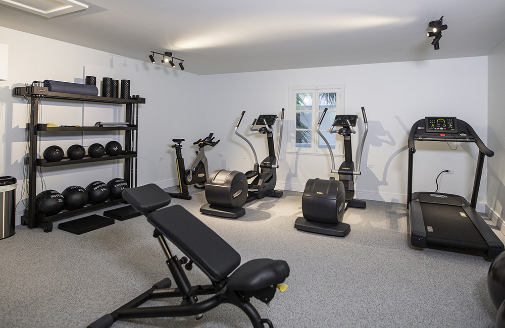 Home gym with various sets of workout equipment