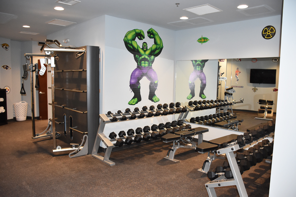 A spacious gym with Hulk and other Marvel heroes decals