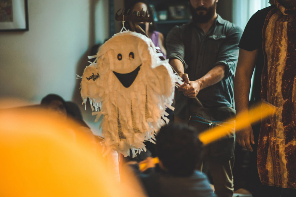A ghost pinata being used at a Halloween-themed birthday party